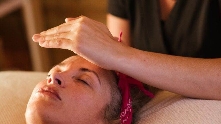 Reiki practitioner resting hands on a person's forehead